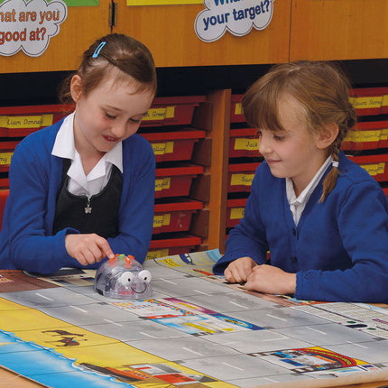 Deux élèves faisant circuler le Blue-Bot sur un tapis de jeu en classe