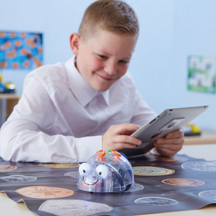 Élève souriant pilotant le Blue-Bot depuis une tablette