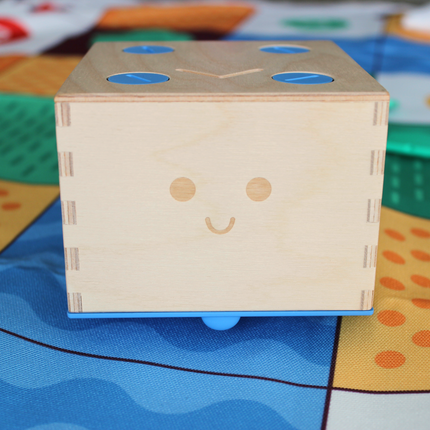 Robot en bois Primo Toys Cubetto+ posé sur sa carte du monde