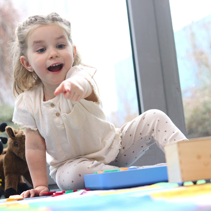 Enfant enthousiaste suivant le trajet du Cubetto+ sur la carte