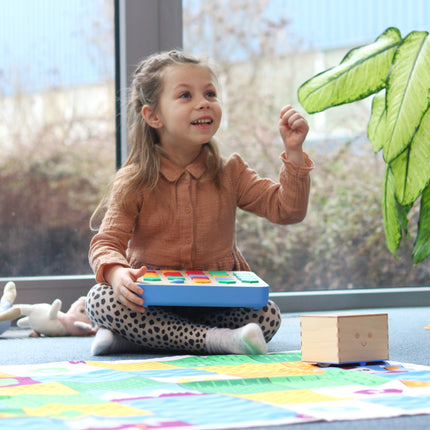 Enfant programmant le Cubetto+ en posant des blocs sur la planche