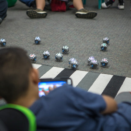 Élèves programmant plusieurs robots Sphero BOLT sur un parcours au sol
